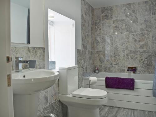 a bathroom with a toilet and a sink and a tub at Waterloo Farm House in Bankfoot