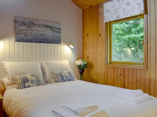 a bedroom with a large white bed with a window at Loch Earn View Lodge in Lochearnhead