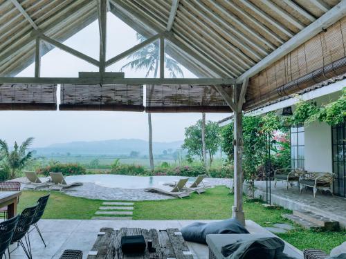 - un pavillon avec vue sur une terrasse dotée de chaises dans l'établissement Sunmoonstarvillas Yogyakarta, à Jarakan