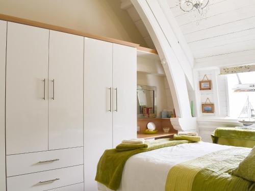 1 dormitorio con armarios blancos y 1 cama en White Sands, en Criccieth