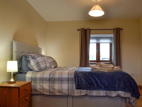 a bedroom with a bed and a window at Trefechan in Pumpsaint