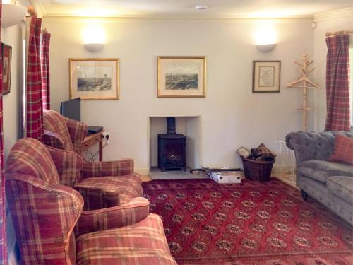 sala de estar con sofá y chimenea en Orchard Cottage At Braidwood Castle - Uk10671, en Braidwood