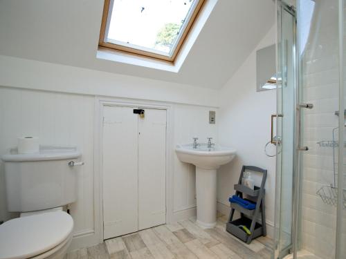 a bathroom with a toilet and a sink and a window at Anchor Loft in Fowey