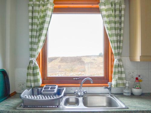 a kitchen sink in front of a window at Hillside - Uk32930 in Gairloch