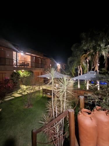 a garden at night with umbrellas in a yard at Confraria da Prata Flats in Pirenópolis