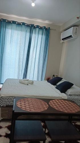 a bedroom with a bed and a table and a window at Seaview and Cityview Mactan,Cebu in Lapu Lapu City