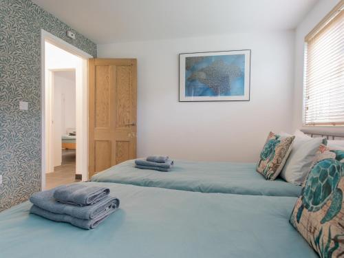 a bedroom with two beds with towels on them at The Boathouse in East Cowes