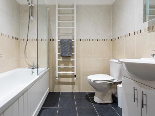 La salle de bains est pourvue de toilettes, d'un lavabo et d'une douche. dans l'établissement The Boathouse, à East Cowes