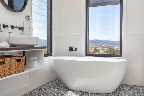 a white bath tub in a bathroom with a window at The Ridge Eco-Cabins - A Secret Place to Slow Down in Gloucester
