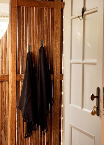 a wooden door with two black jackets hanging on it at 28 Degrees Byron Bay - Adults Only in Byron Bay