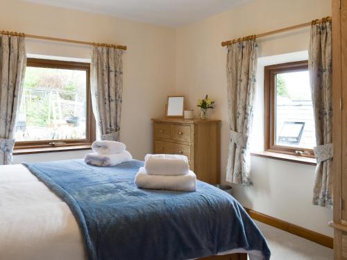 1 dormitorio con 1 cama con 2 almohadas en The Old Candle House en Longnor
