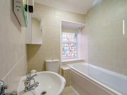 a bathroom with a sink and a tub and a toilet at Margaret House in Chirnside