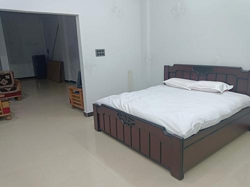 a bed with white sheets and pillows in a bedroom at Narayan nivas homestay in Ujjain