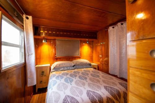 1 dormitorio con 1 cama en una habitación pequeña en Vintage Trailer - Cute Spot for Budget Travelers en Anchorage