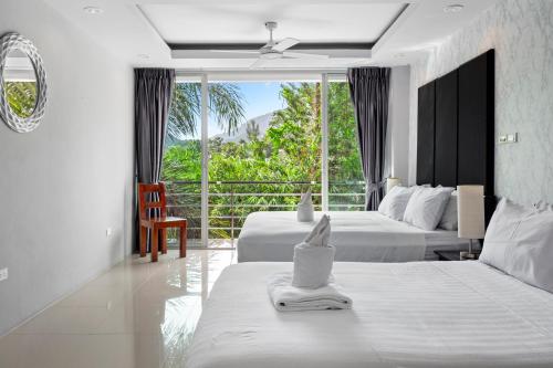 a hotel room with two beds and a balcony at The Fairways Villas - 5 bedrooms & bathroom for up to 14 guests 7kms to Patong in Kathu