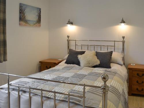 a bedroom with a metal bed with two pillows at The Nook At Balcary in Auchencairn