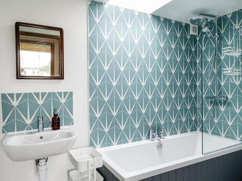 a bathroom with a sink and a toilet and a mirror at The Barn At Daubeneys in Colerne