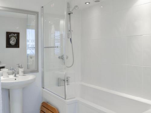 a white bathroom with a shower and a sink at Ruach in Gardenstown