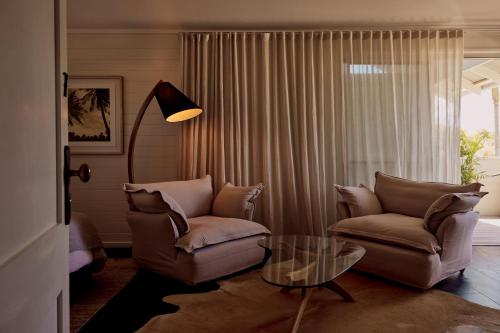 a living room with a couch and a glass table at 28 Degrees Byron Bay - Adults Only in Byron Bay