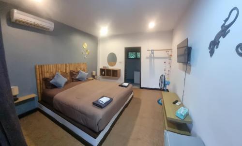 a bedroom with a large bed with a wooden headboard at Pink House in Lamai