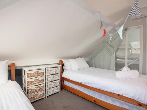 a bedroom with two beds and a mirror at The Lookout in Salcombe