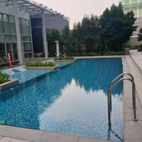 a swimming pool in a building with blue water at Cozy 1BR UPTOWN PARKSUITES Tower1 BGC in Manila