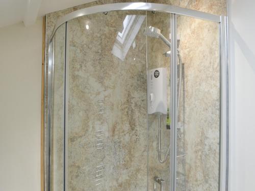 een douche met een glazen deur in de badkamer bij Croft Cottage in Sharperton