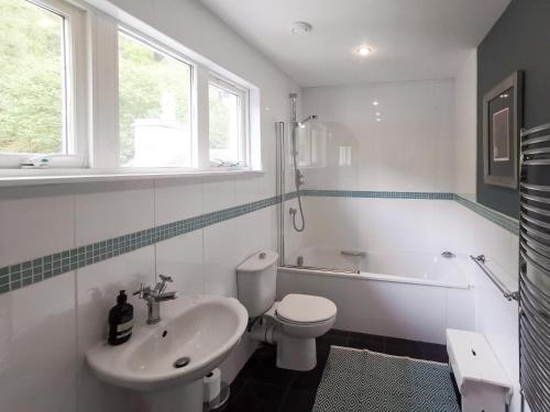 a white bathroom with a sink and a toilet at Cliff Cottage in Port Appin