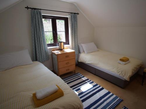 a small bedroom with two beds and a window at Dardy Cottage in Crickhowell