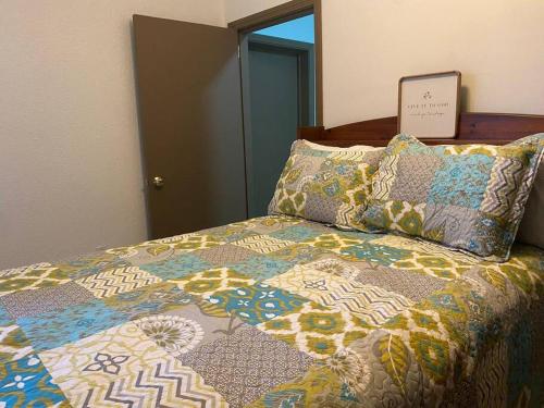 een bed met een kleurrijke quilt en kussens erop bij Departamento céntrico in Tijuana