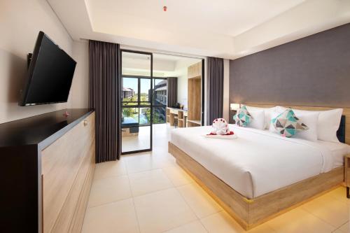a bedroom with a large bed with a flat screen tv at Anagata Hotels and Resorts Tanjung Benoa in Nusa Dua