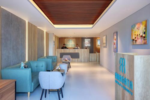 a lobby of a hospital with blue chairs and a counter at Anagata Hotels and Resorts Tanjung Benoa in Nusa Dua