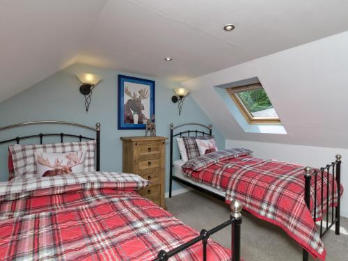 two beds in a bedroom with a attic at Creebank in Newton Stewart