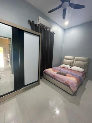 a bedroom with a bed and a ceiling fan at Casa Permai Temerloh in Temerloh