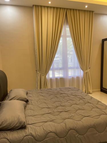 a bedroom with a bed and a window with curtains at Casa Permai Temerloh in Temerloh