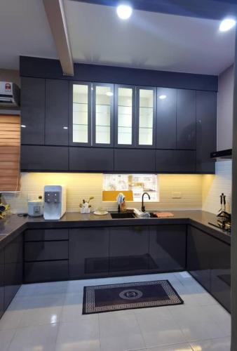 a kitchen with black cabinets and a sink at Casa Permai Temerloh in Temerloh