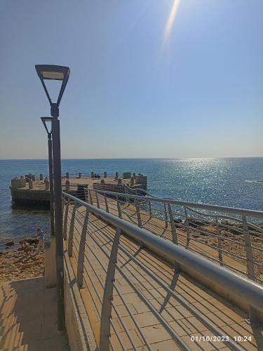 a street light next to a beach with the ocean at Casa Carruvedda in Avola