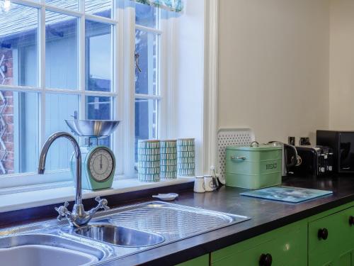 a kitchen counter with a sink and a window at Old Upper Gwestydd in Highgate