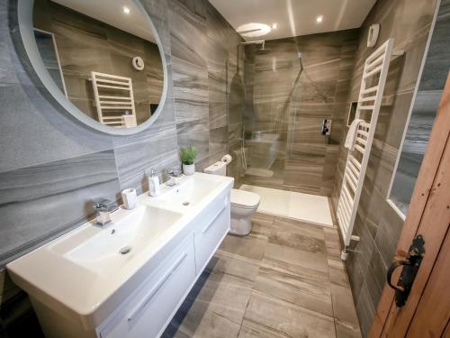 a bathroom with a sink and a toilet and a mirror at Dunmail House in Grange Over Sands