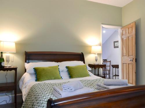 een slaapkamer met een groot bed met groene kussens bij Oxtobys Upstairs in York