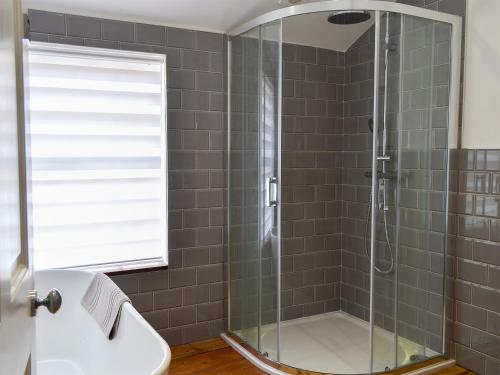 een badkamer met een glazen douche en een wastafel bij Oxtobys Upstairs in York