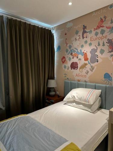 a bedroom with a bed and a wall with animals at Private Cozy House in Pakuwon in Surabaya