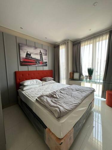 a bedroom with a large bed in a room with windows at Private Cozy House in Pakuwon in Surabaya