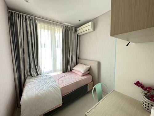 ein kleines Bett in einem kleinen Zimmer mit Fenster in der Unterkunft Private Cozy House in Pakuwon in Surabaya