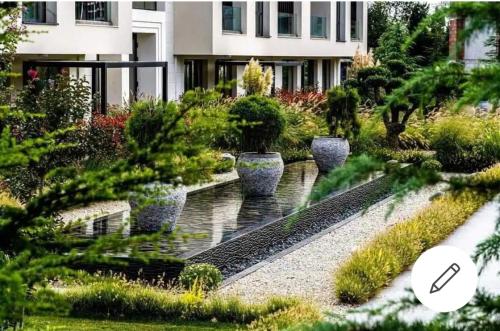 a garden with a fountain and plants in front of a building at ALLURE VARNA studios in St. St. Constantine and Helena