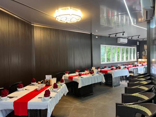 a dining room with tables and chairs with red accents at Halo Retreat in Hòa Bình