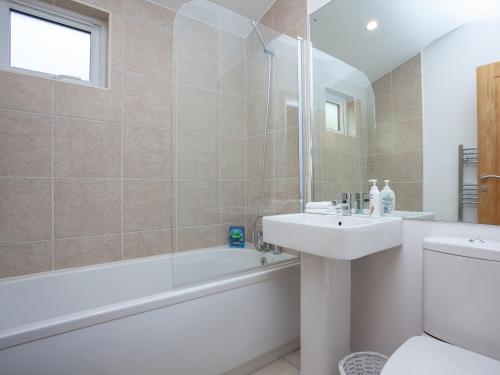 a bathroom with a tub and a sink and a toilet at Moornook 7-uk36703 in Newton Abbot