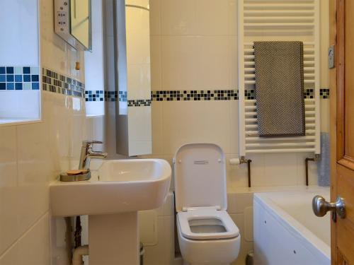 y baño con lavabo y aseo. en Scira, en Sheringham