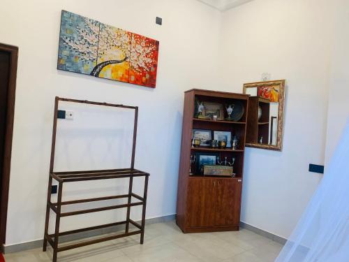 a room with a mirror and a shelf and a painting at Kavin Beach Hotel Hikkaduwa in Hikkaduwa