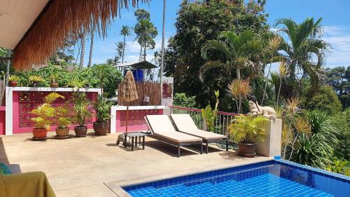 a patio with a chair and a swimming pool at Pink House in Lamai